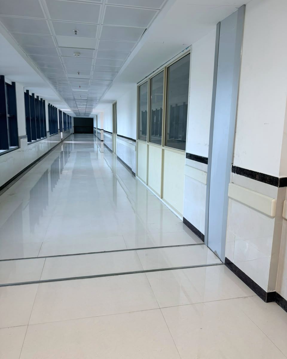 Floor expansion joint crossing a corridor, with a wall joint cover on the right