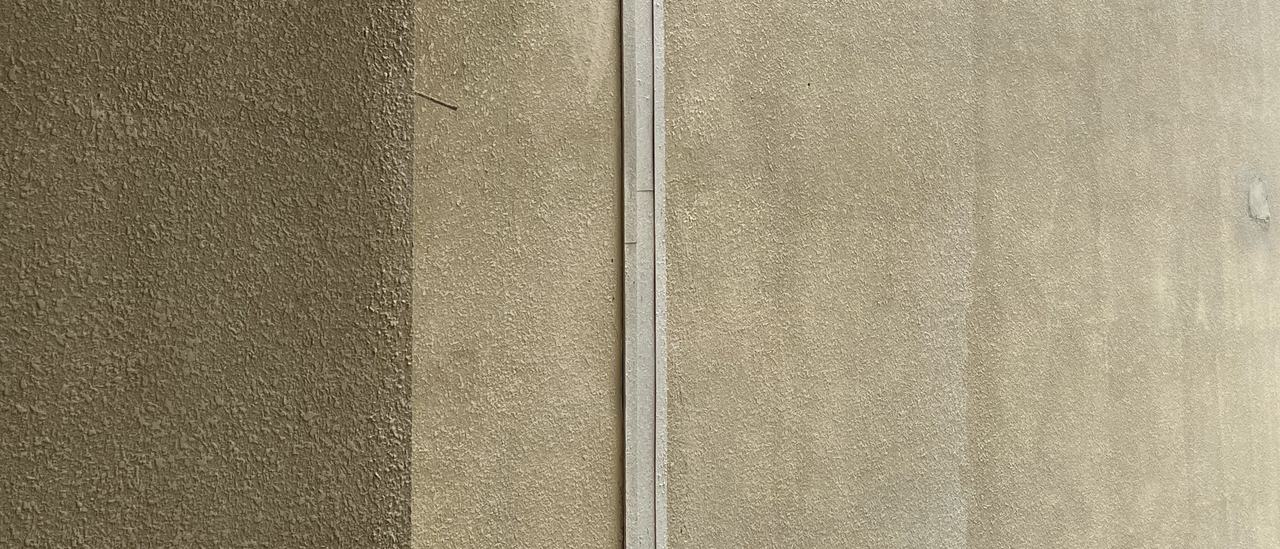 A vertical wall expansion joint up a façade column, landscaping at its foot, Bengaluru